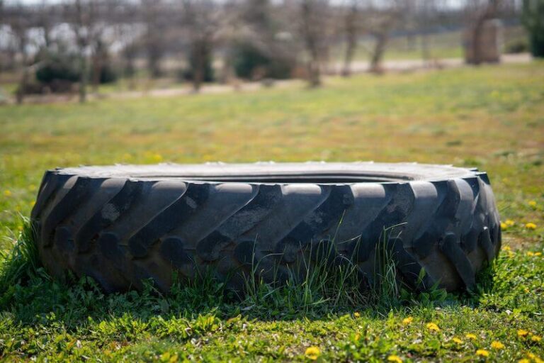 closeup tractor tire field with yellow flowers 2